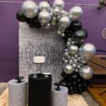 Leia mais sobre o artigo Festa com Painel de Glitter Prata – Trabalho em Balões Preto e Prata com Arco Orgânico